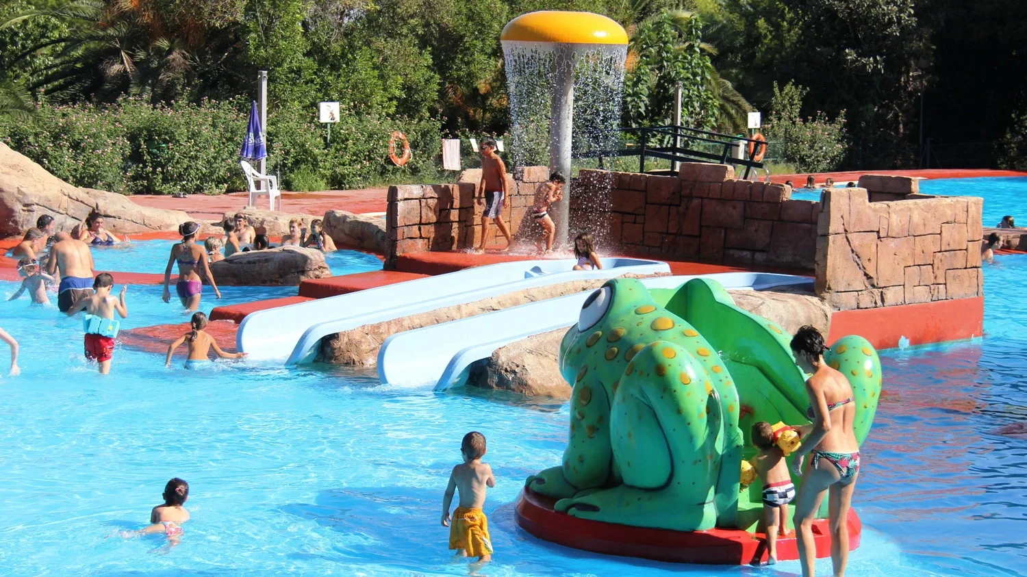 Piscina municipal Parc Vedat en Torrent con toboganes y zona infantil, una de las mejores para el verano en Valencia Familias y niños disfrutando en la piscina Parc Vedat de Torrent, con toboganes y juegos acuáticos, durante el verano en Valencia